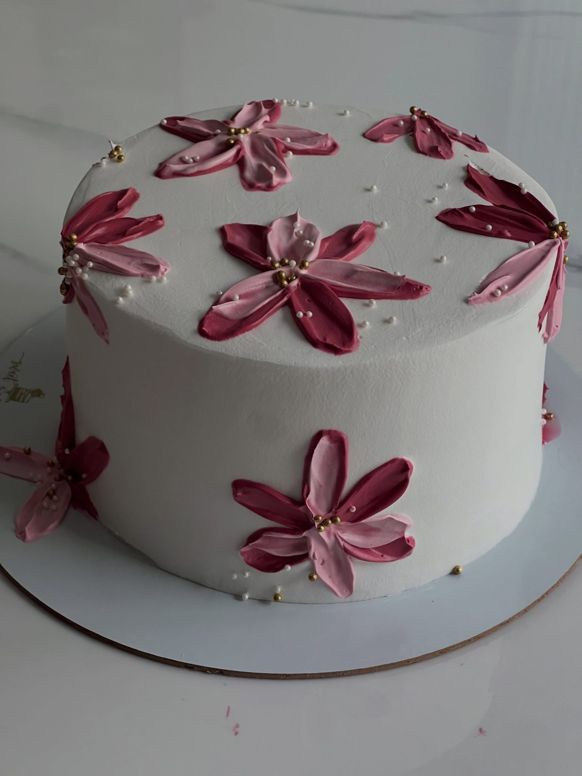 White celebration cake with burgundy chocolate flowers
